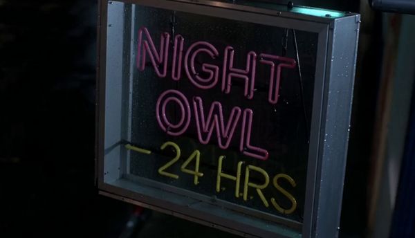 SeeDance 2.0 output for the prompt: Extreme close-up of a neon diner sign flickering on that reads "NIGHT OWL — 24 HRS" in pink and yellow tubes, rain streaming down the glass behind it. 1990s aesthetic.