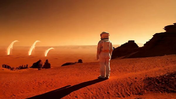 Minimax output for the prompt: A single astronaut stands on a red Martian plain with their back to the camera. The camera dollies forward slowly over 4 seconds. Dust devils swirl in the distance. Sunset lighting.