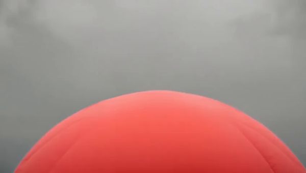 Mochi output for the prompt: A single red balloon rises slowly against a plain overcast grey sky. Nothing else in the frame. 4 seconds.