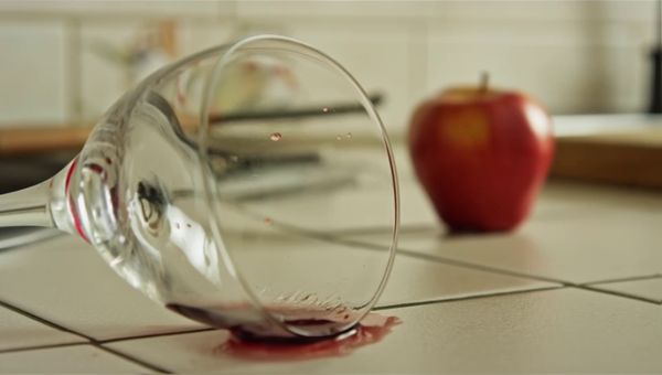 Luma Ray 2 output for the prompt: A ripe red apple falls from a kitchen countertop and shatters a wine glass on the tile floor below. Shards scatter, juice splashes. 24fps, natural morning light.