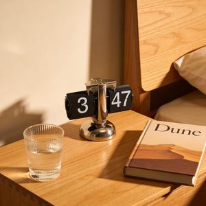 Seedream 4.5 output for the prompt: A clock showing 3:47 on a bedside table, with a glass of water to the LEFT and a book titled "Dune" to the RIGHT