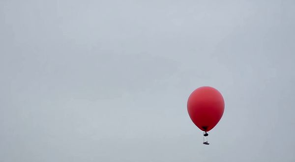 Wan v2.2 output for the prompt: A single red balloon rises slowly against a plain overcast grey sky. Nothing else in the frame. 4 seconds.