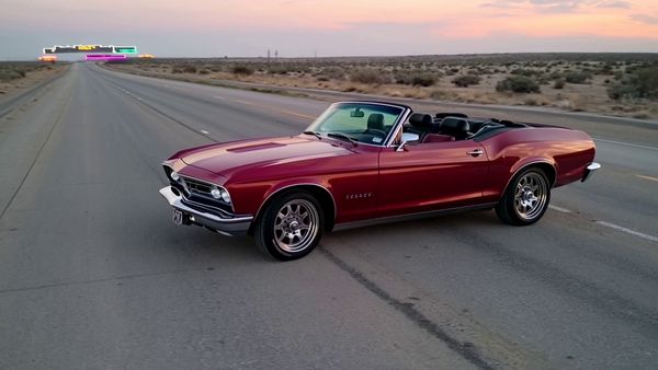 Kling 1.6 Pro output for the prompt: Slow orbit around a 1965 Mustang convertible parked on a Nevada desert highway at twilight. Neon motel sign blinking in the background. Cinematic widescreen.