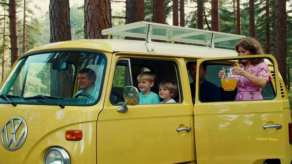 SeeDance 1.0 Lite output for the prompt: Super 16mm film grain, Kodachrome color: a family of four having a picnic in a yellow VW bus parked by a redwood forest. Children laughing, mom pouring lemonade.