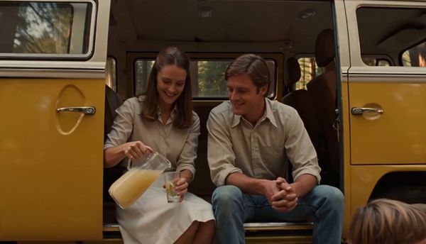 SeeDance 2.0 output for the prompt: Super 16mm film grain, Kodachrome color: a family of four having a picnic in a yellow VW bus parked by a redwood forest. Children laughing, mom pouring lemonade.