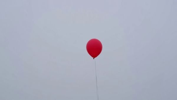 Luma Ray 2 output for the prompt: A single red balloon rises slowly against a plain overcast grey sky. Nothing else in the frame. 4 seconds.